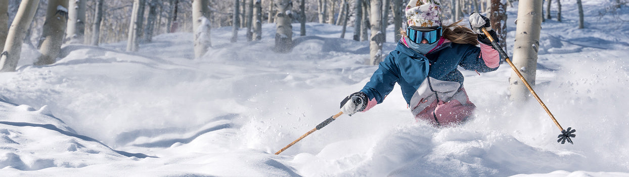 skier pow turn in aspen trees