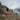 man and woman running thawed out high alpine mountain trail wearing scout jackets