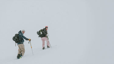 man and woman smiling ski touring in white out conditions