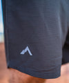 lifestyle image of strafe outerwear summer 2023 ms savage training short in charcoal