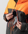 studio image of strafe outerwear 2023 cham 3l shell jacket in tangerine color
